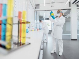 Laborwissenschaftler in Schutzkleidung, die chemische Proben analysieren